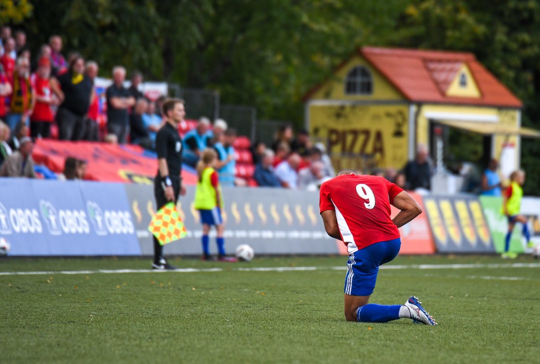 Johnny Buduson må her ut med skade mot Fløy på Nordre Åsen 1. september. Bekymrede okser i bakgrunnen.
